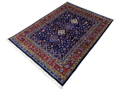 Oriental rug with a blue background, red borders, and a symmetrical medallion pattern