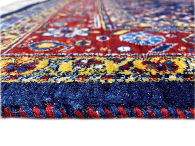 Rug border with a colorful pattern and blue and red fringes