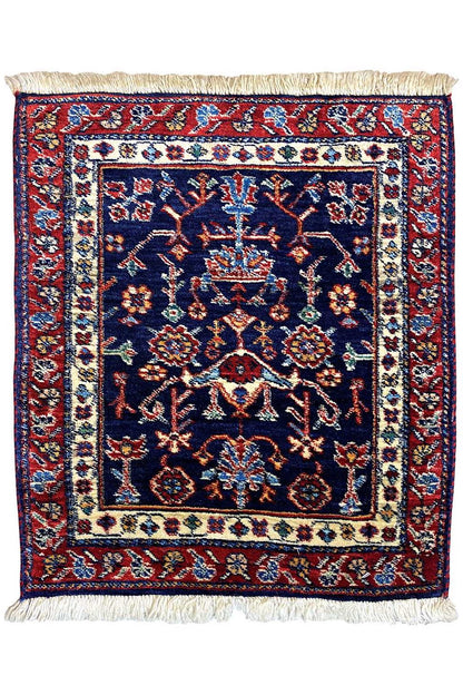 Square rug with a blue central medallion, red border ornaments, and fringes