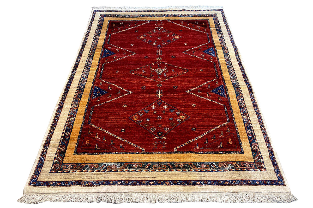 Oriental rug, red field with diamond and medallion motifs, blue borders, fringes
