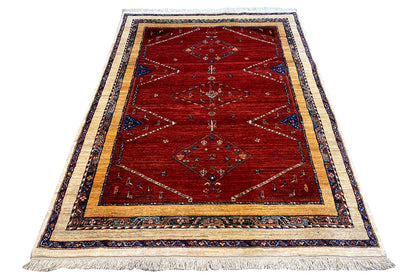 Oriental rug, red field with diamond and medallion motifs, blue borders, fringes