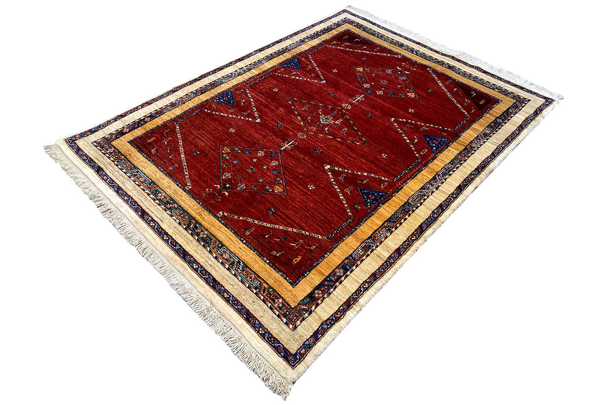 Oriental rug, red field with a diamond medallion, blue-and-cream linear border, fringes