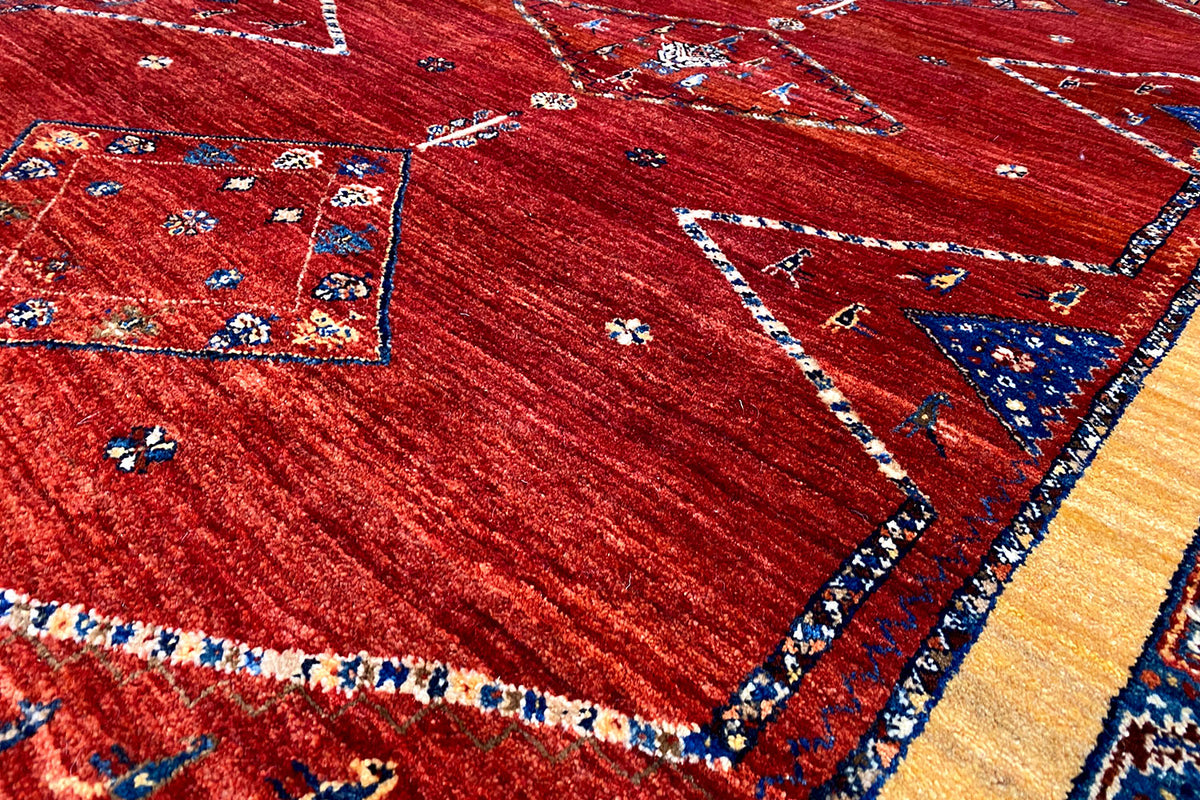 Close-up: red carpet with a blue border, delicate decorative lines, and small pattern details