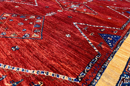 Close-up: red carpet with a blue border, delicate decorative lines, and small pattern details