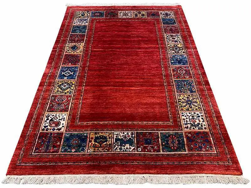 Red rug with medallion field and blue ornamental border, fringes