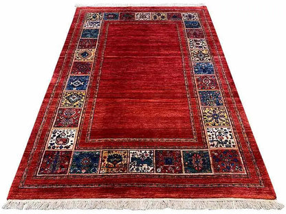 Red rug with medallion field and blue ornamental border, fringes