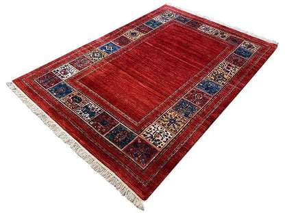 Red carpet with a blue ornamental border and white fringe, diamond-shaped