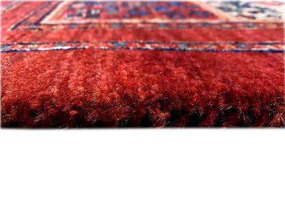Red high-pile carpet with a blue patterned border along the edge