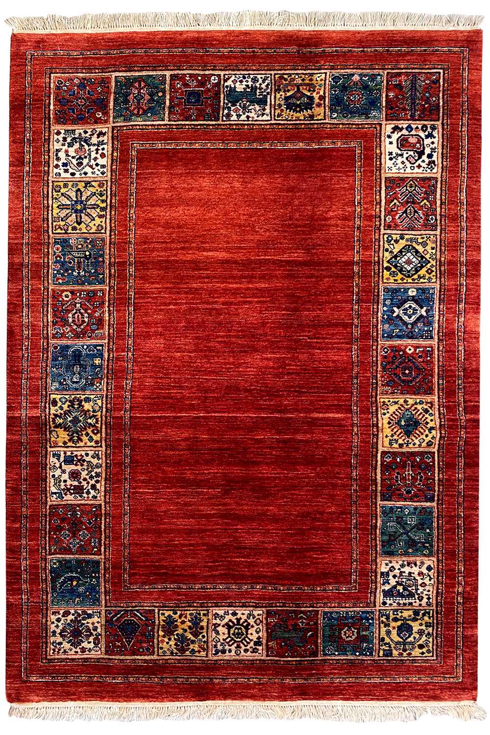 Rectangular red rug with a blue tiled border and white fringes