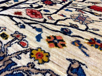 Close-up: beige carpet with a colorful ornamental pattern, featuring blue, red, and yellow details.