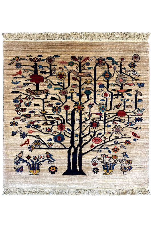 Square beige rug with a tree motif, colorful birds and flowers, fringed edges.