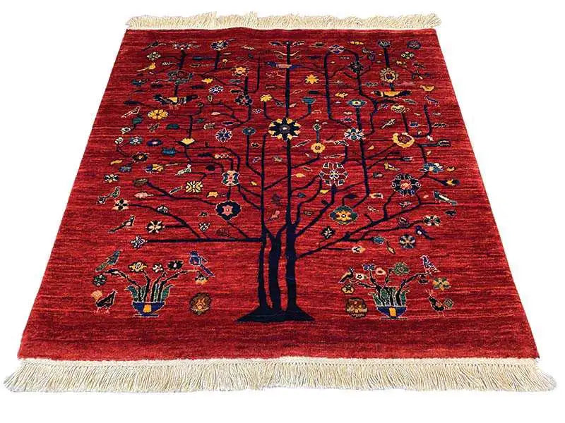 Red Oriental rug with a central tree, colorful ornaments, and beige fringes.