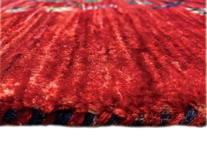 Red carpet with a dense pile and delicate pattern, close-up of the surface.