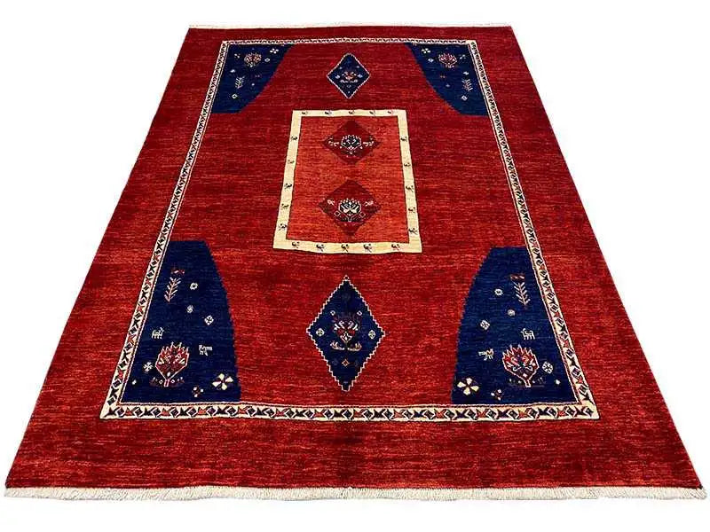 Rug in a red base tone with blue fields, a cream-colored border, and geometric motifs