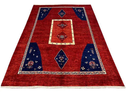 Rug in a red base tone with blue fields, a cream-colored border, and geometric motifs