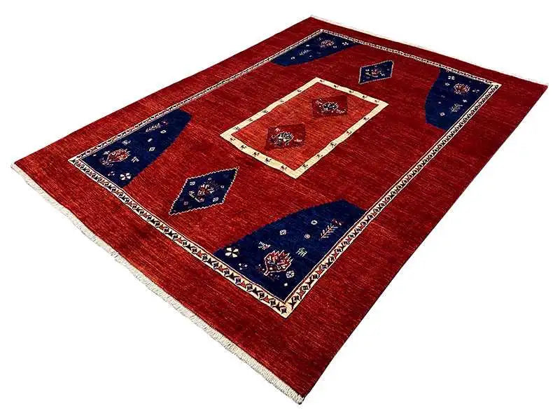 Red-pile rug with blue corner motifs, a cream-colored border and central ornament
