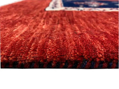 Close-up of red carpet pile with a dark blue border and fringe line