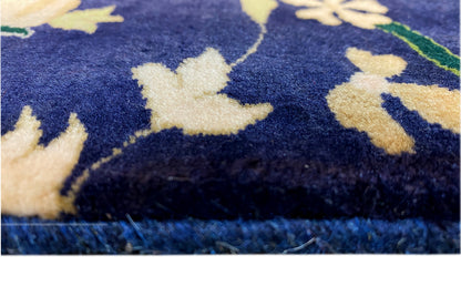 Carpet fabric in detail, dark blue with light-colored flowers and a floral pattern, fringe