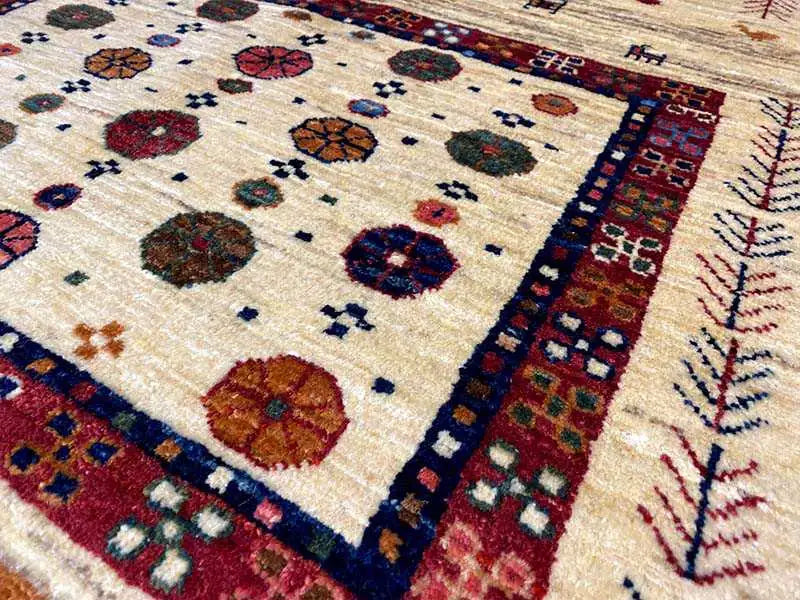 Oriental rug: Detail with dot and floral motifs, cream background, blue and red