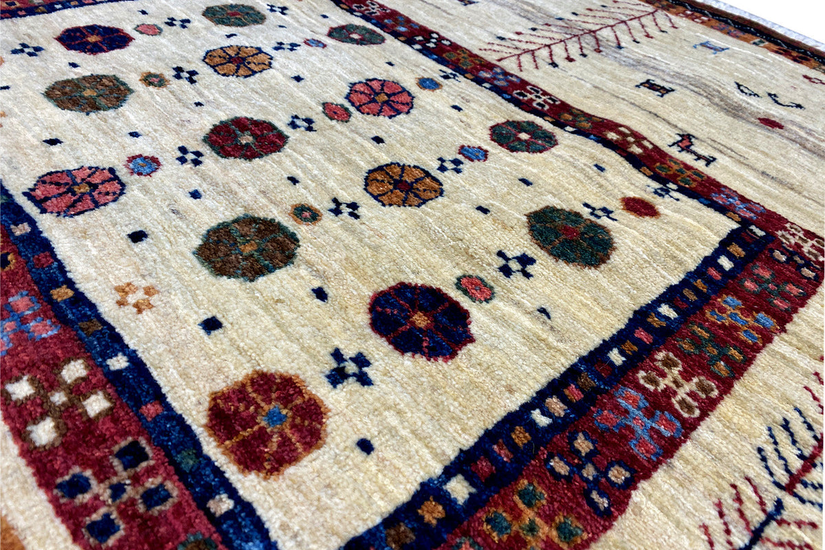 Close-up of a carpet pattern, beige background with colorful circles and tree ornaments