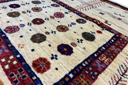 Close-up of a carpet pattern, beige background with colorful circles and tree ornaments