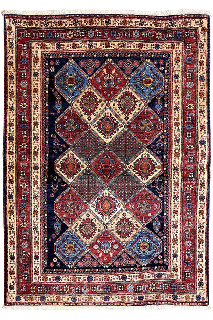 Rectangular rug with a light background and symmetrical diamond pattern in red and blue