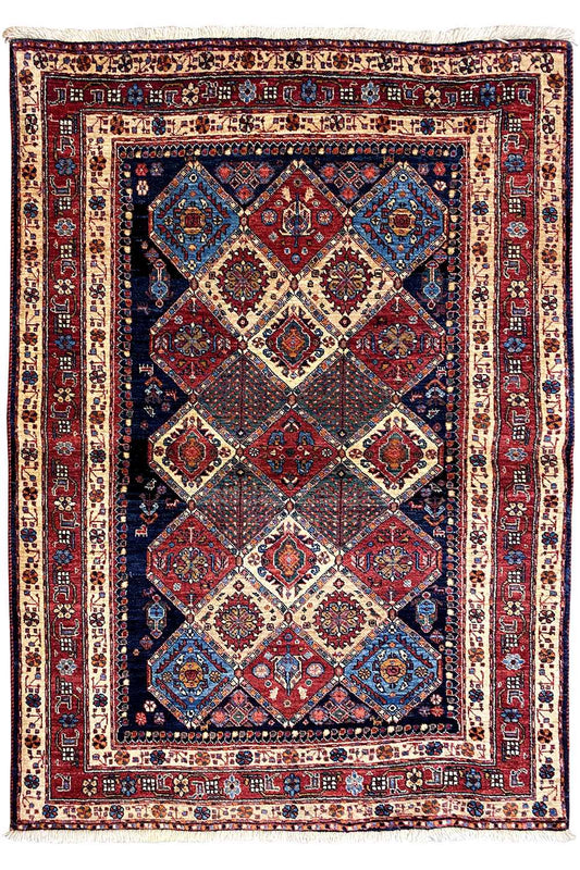 Rectangular rug with a light background and symmetrical diamond pattern in red and blue