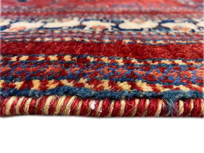 Close-up: red runner with fringes and multicolored woven pattern