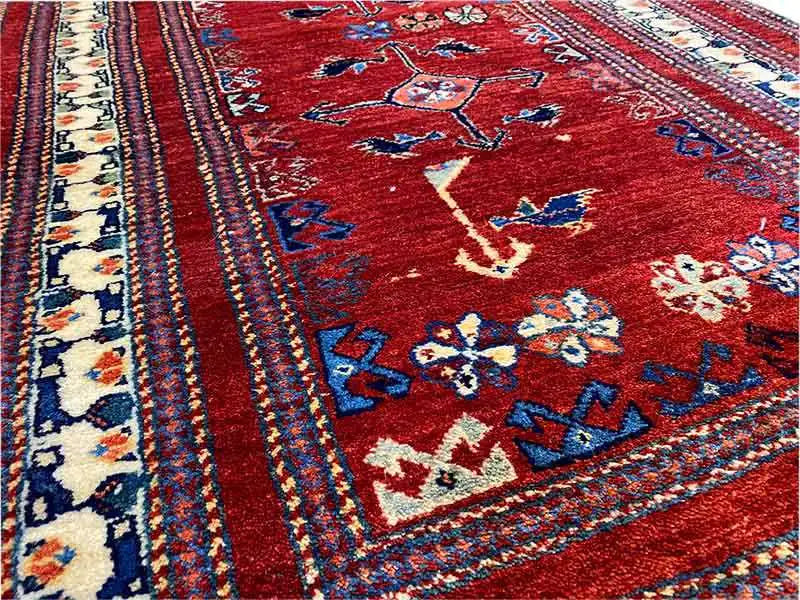 Red runner with a blue and cream ornamental pattern in the center