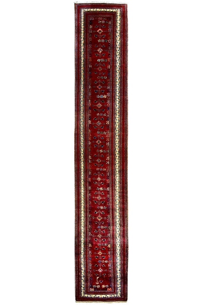 Narrow red runner with a rectangular border and a fine multicolored trim