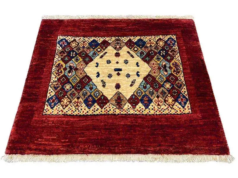 Rug 74x60 cm with a red border, a cream medallion, and colorful ornaments