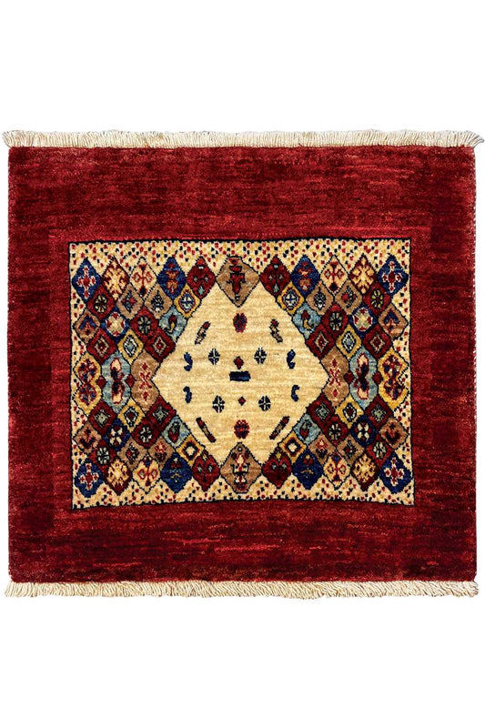Rug 74x60 cm viewed from above: red border, symmetrical diamond ornaments, and fringes