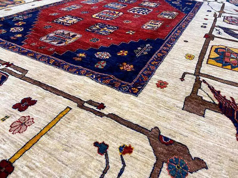 Oriental rug with a red center, blue border, and cream-colored background, detail crop