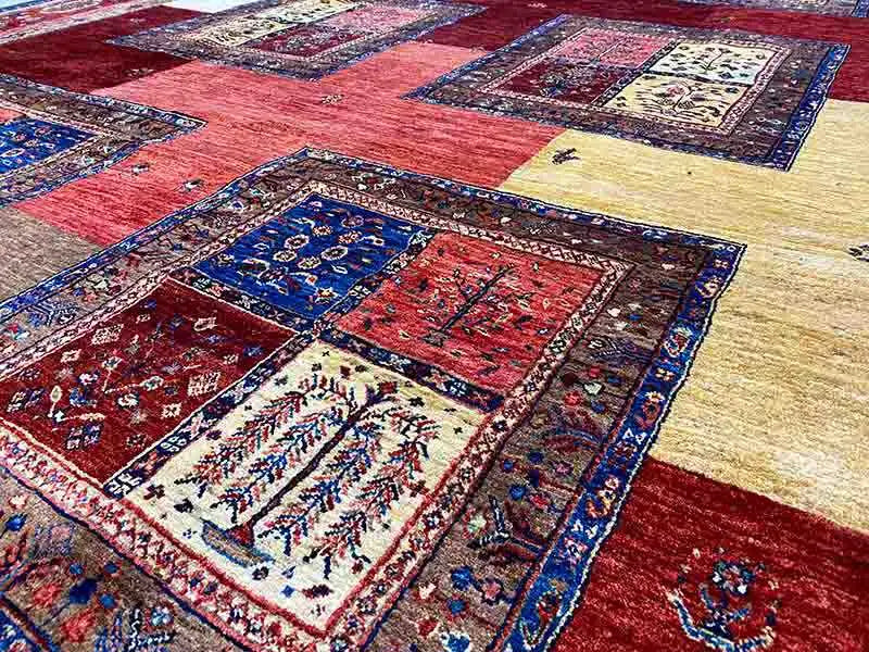 Detailed view: Patchwork rug sections in red, blue, and beige with delicate patterns