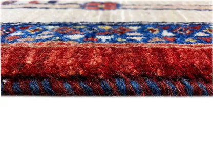 Carpet edge with a red pile area and blue decorative border, coarse fringe