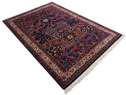 Oriental rug with dark blue, red, and an ornamental border, diagonal view