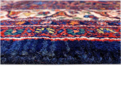 Carpet fringes and border in dark blue, red, and turquoise in detail
