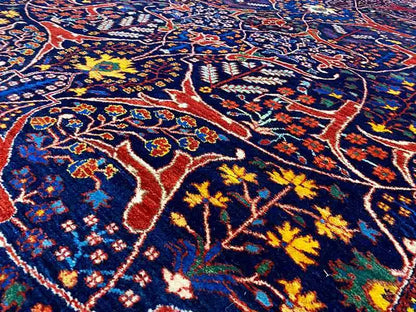 Close-up view of the carpet pattern in dark blue, red, and yellow with floral motifs