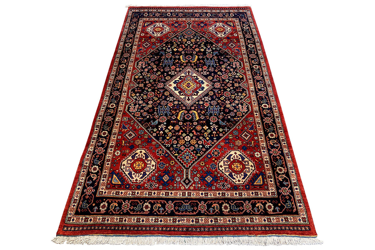 Rug with a dark blue center, red corner ornaments, and woven borders