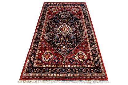 Rug with a dark blue center, red corner ornaments, and woven borders