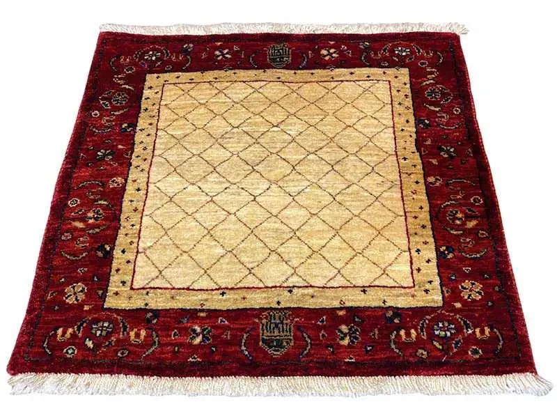 Square rug with a red border, beige center and ornaments, fringes