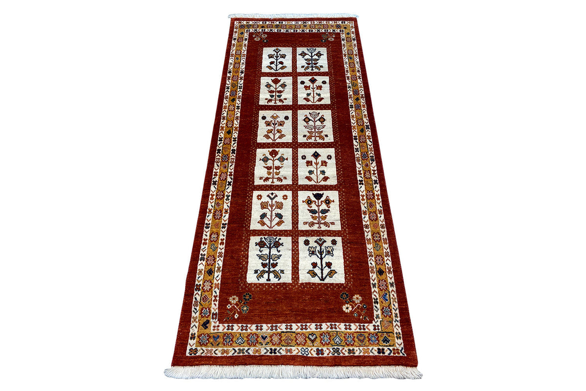 Oriental rug with a red central section, decorative border, and multicolored ornaments.