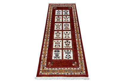 Oriental rug with a red central section, decorative border, and multicolored ornaments.