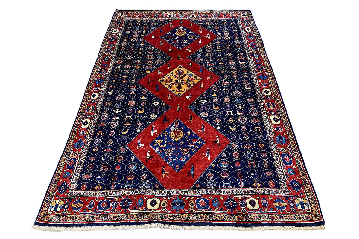 Blue-red oriental rug in oblique view, red central field and border