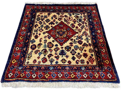 Square oriental rug with a red medallion, cream-colored background, and blue border