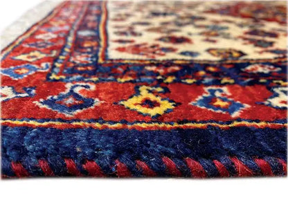 Oriental rug detail with blue pile and a red stripe pattern along the edge