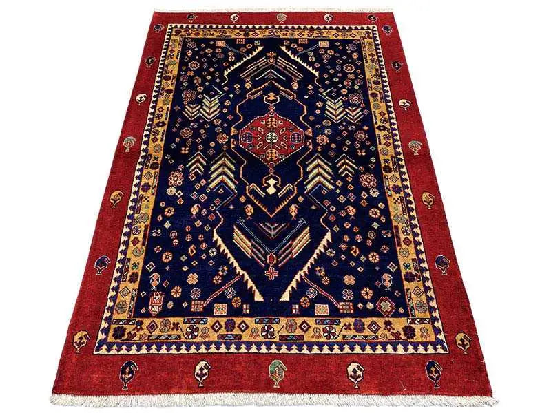 Dark blue rug with a red border and geometric medallion design, short fringes.