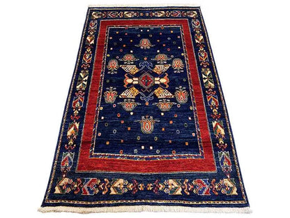 Rug: dark blue with a red border and central medallion ornaments