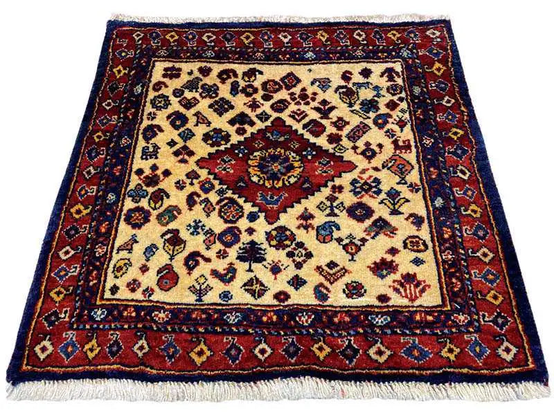 Qashqai exclusive rug with a red border, beige central field, and fringes