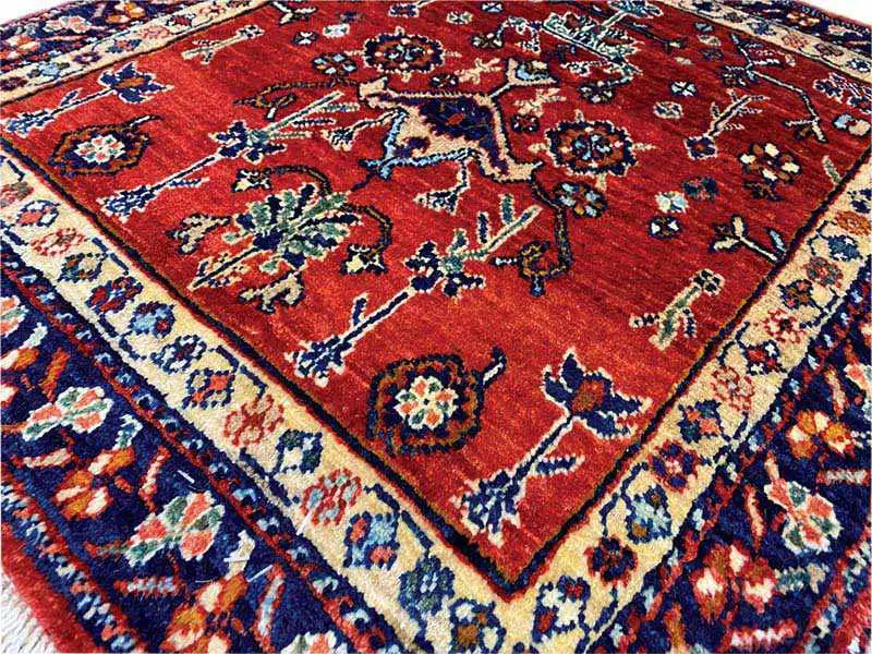 Carpet detail with a red background, multicolored floral ornaments, and a blue border